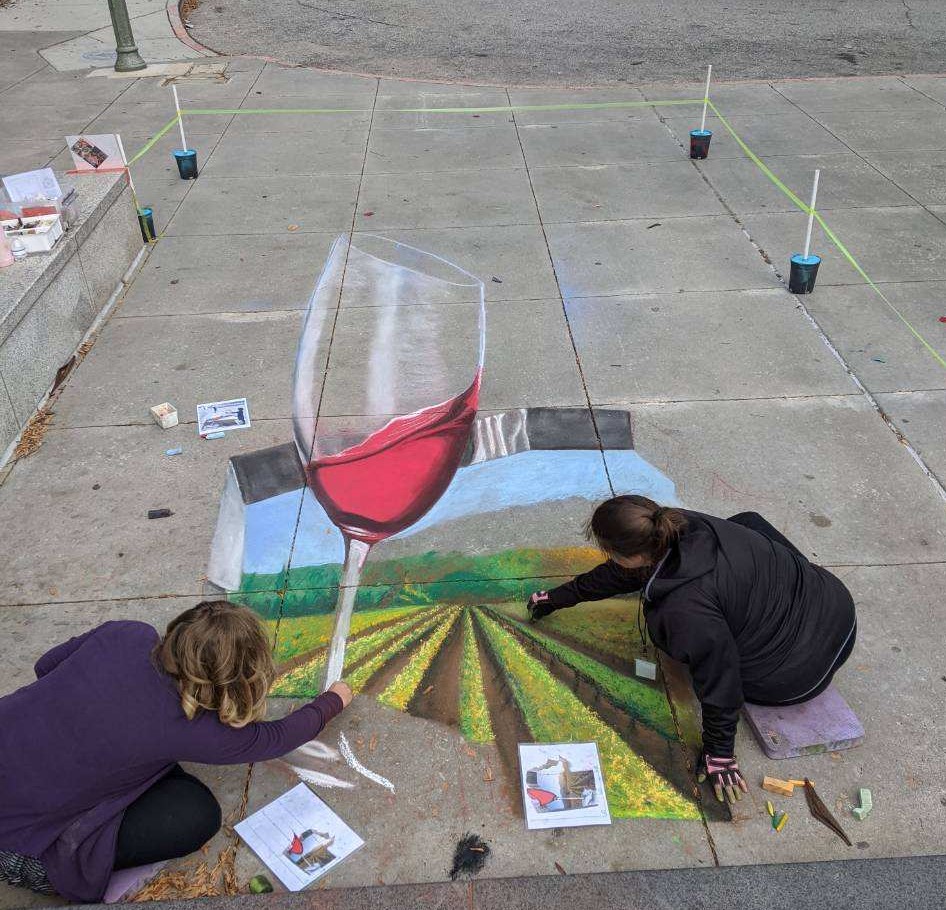 chalk art drawing of wine glass in front of vineyard